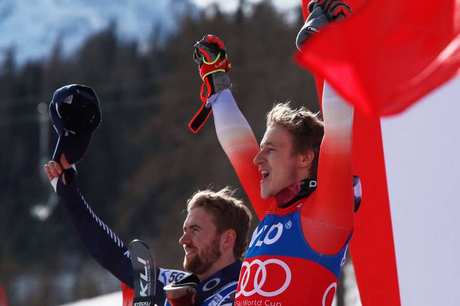 Marco Odermatt celebrates on the podium after placing first alongside second placed Norway's Aleksander Aamodt Kilde