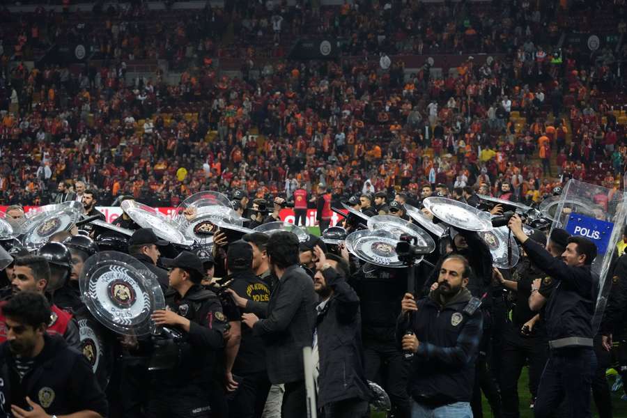 Fenerbahçe-spelers werden met flinke bescherming naar de kleedkamers geleid