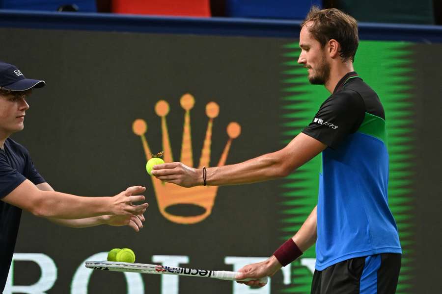 Daniil Medvedev gives a ball with a butterfly on it to a ballboy during his match against Cristian Garin