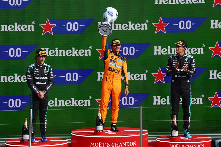 Norris celebrates his victory on the podium alongside Antonelli (L) and Russell (R) Norris celebrates his victory on the podium alongside Antonelli (L) and Russell (R)