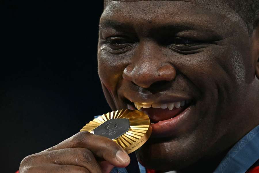 Mijaín López mordiendo su medalla de oro en París 2024.