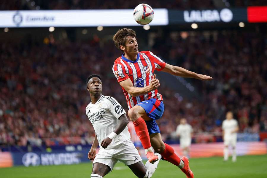 Real Madrid's Vinicius Junior in action with Atletico Madrid's Robin Le Normand (right)