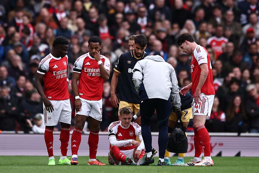 Arsenal's Norwegian midfielder Martin Odegaard (C) reacts after picking up an injury