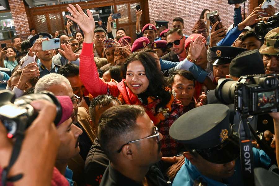 Palesha Goverdhan (C) greets the crowd upon her arrival at Tribhuvan International Airport in Kathmandu