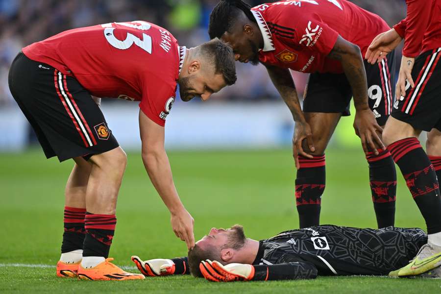 Players attend to David de Gea after he is hit in the face by the ball