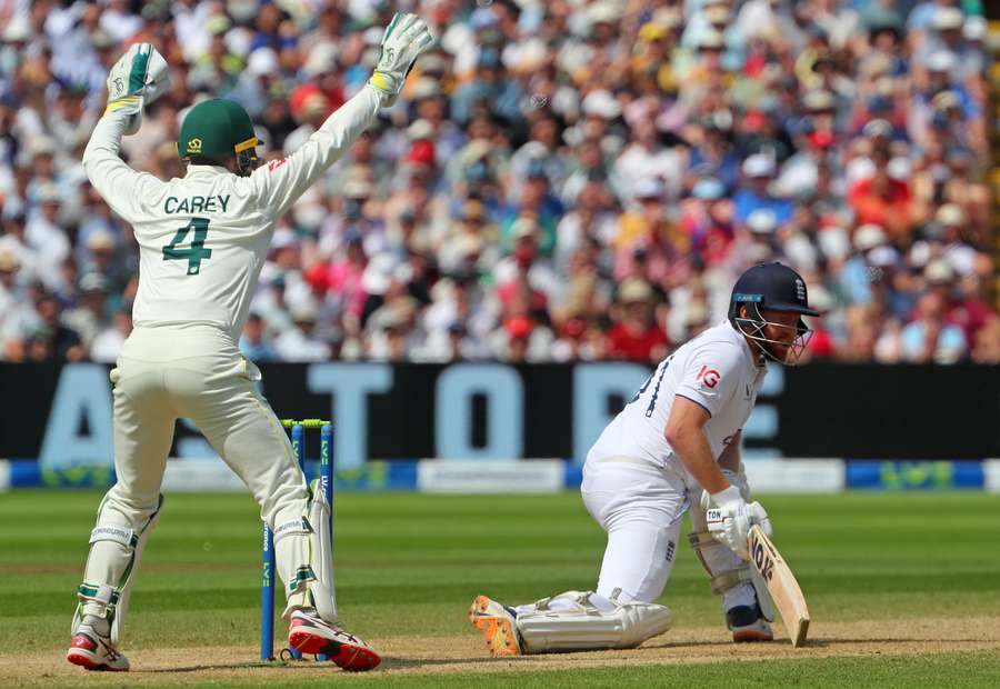 Australia's wicket keeper Alex Carey (L) reacts as England's Jonny Bairstow loses his wicket lbw on day four of the first Ashes cricket Test match