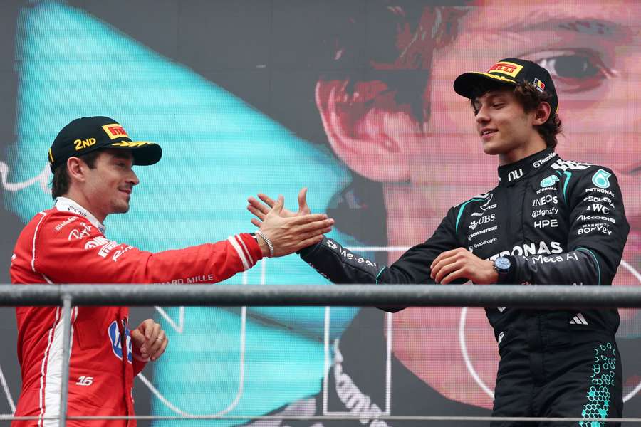 Mercedes' Antonelli shakes hands with Ferrari's Leclerc on the podium after winning the Belgian Grand Prix