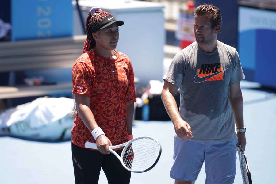 Osaka speaks to her coach, Wim Fissette, during training