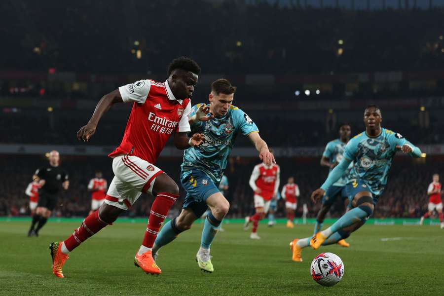 Arsenal's English midfielder Bukayo Saka vies with Southampton's French defender Romain Perraud in the build-up to their first goal