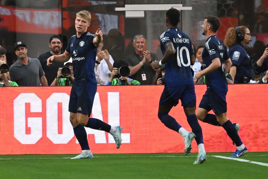 Manchester United's Danish forward #09 Rasmus Hojlund (L) reacts after scoring a goal