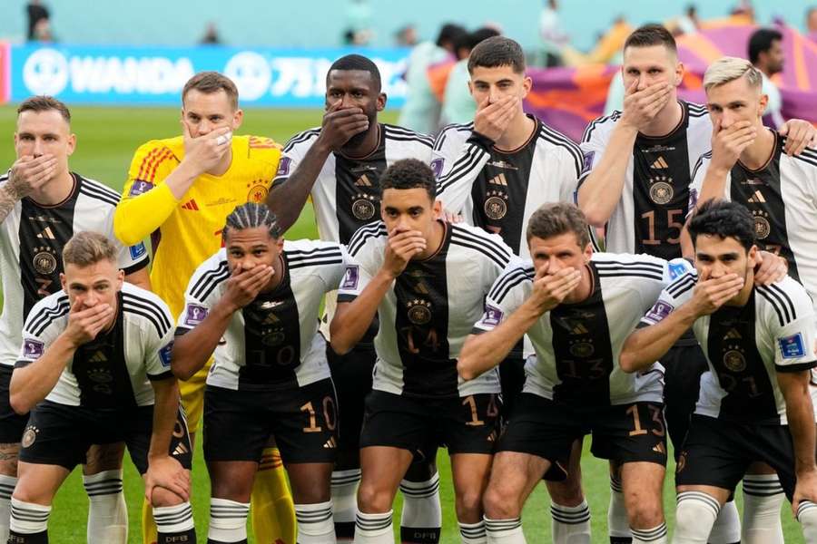 Tyske VM-spillere holder sig for munden på holdfoto.
