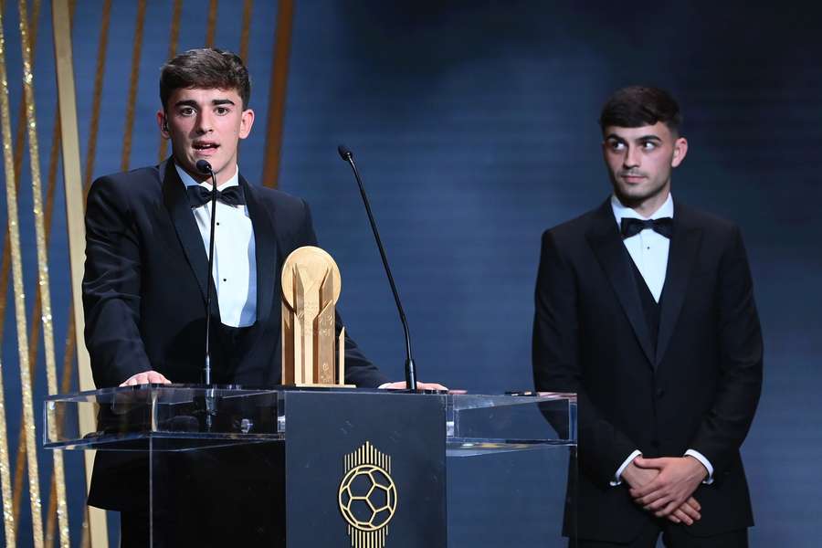 Barcelona's Spanish midfielder Gavi poses with the Kopa Trophy for best under-21 player next to teammate Pedri 