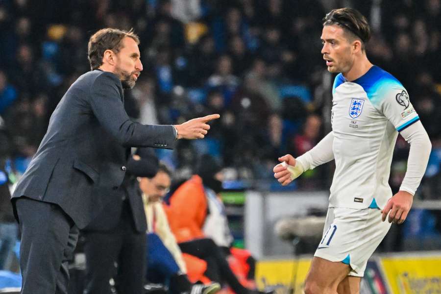 England's coach Gareth Southgate (L) gives instructions to Jack Grealish