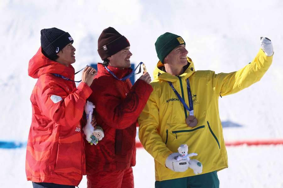 O medalhista de ouro Mikael Kingsbury, o medalhista de prata Ikuma Horishima e o medalhista de bronze Matt Graham tiram uma selfie no pódio