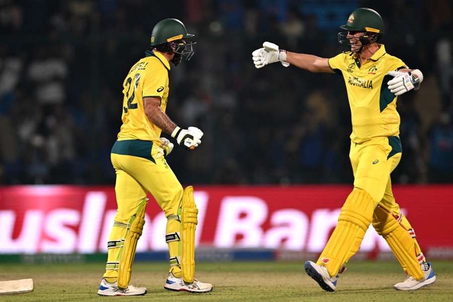 Australia's Glenn Maxwell (L) celebrates with his team captain Pat Cummins after scoring a century