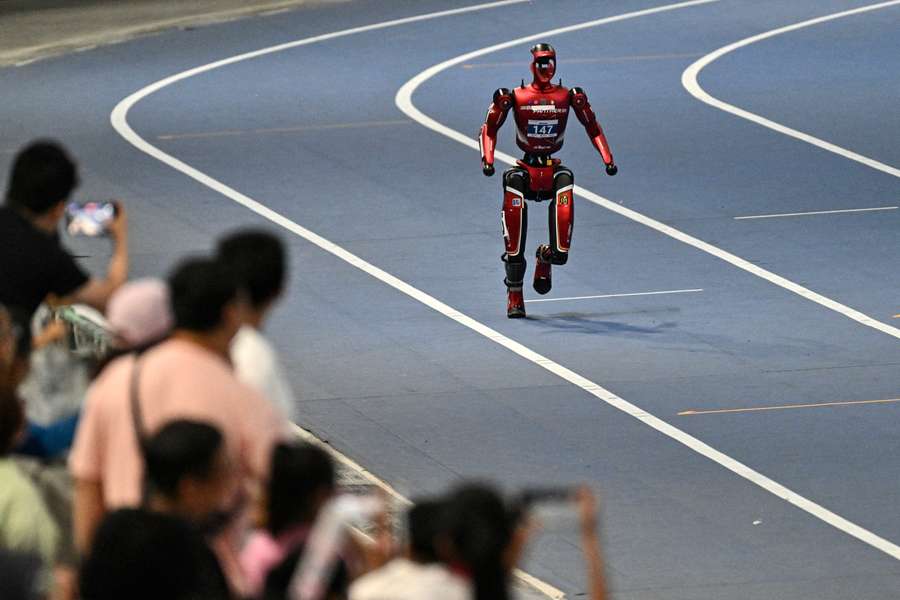 Spectators watch a robotic sprinter in Beijing. Spectators watch a robotic sprinter in Beijing.