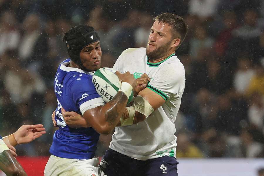 Samoa centre Ulupano Junior Seuteni is tackled by Ireland centre Stuart Mccloskey (R)