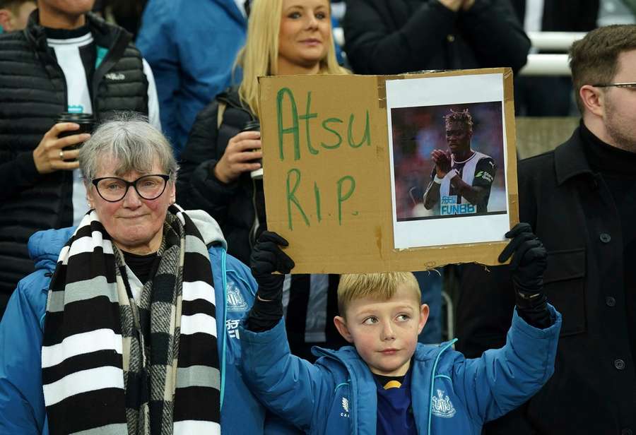 A Newcastle United fan holds up a sign in memory of Christian Atsu