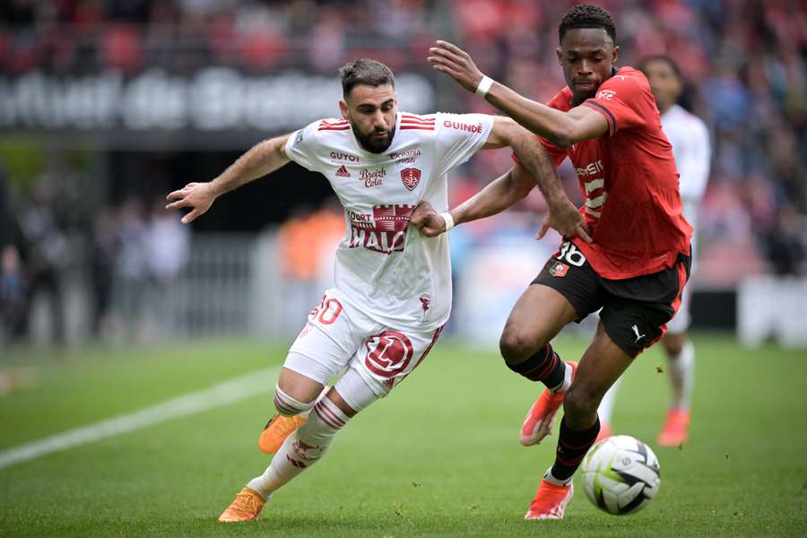 Rennes' French defender Jeanuel Belocian fights for the ball with Brest's French forward Romain Del Castillo