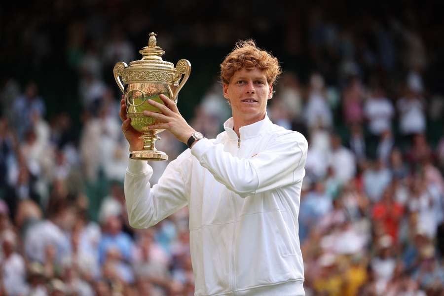 Jannik Sinner celebrates with the winner's trophy after beating Carlos Alcaraz in the final