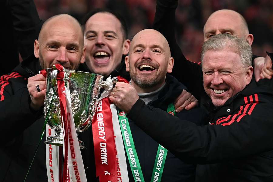 Manchester United's Dutch manager Erik ten Hag and his assistants celebrate with the trophy