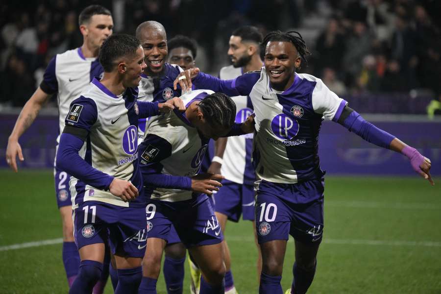 Toulouse's Cameroonian forward Frank Magri is congratulated by teammates after scoring