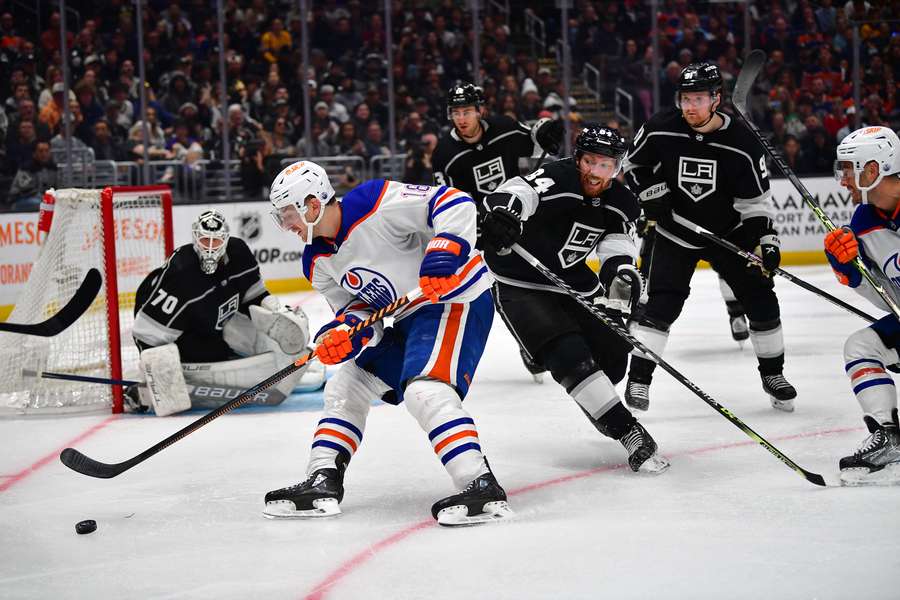 Oilers linkervleugel Hyman beweegt de puck tegen Kings verdediger Gavrikov