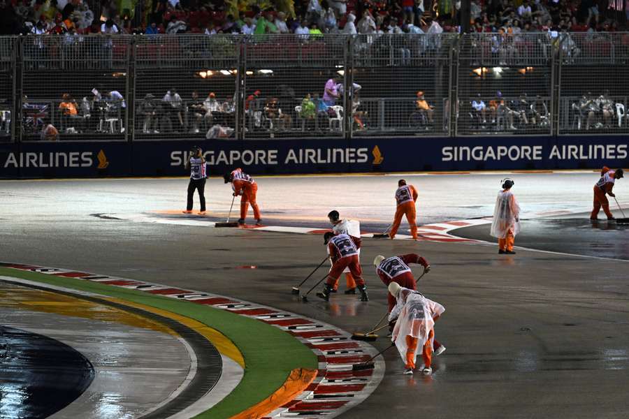 Los comisarios intentan secar el trazado de Marina Bay tras la lluvia que ha caído en Singapur.