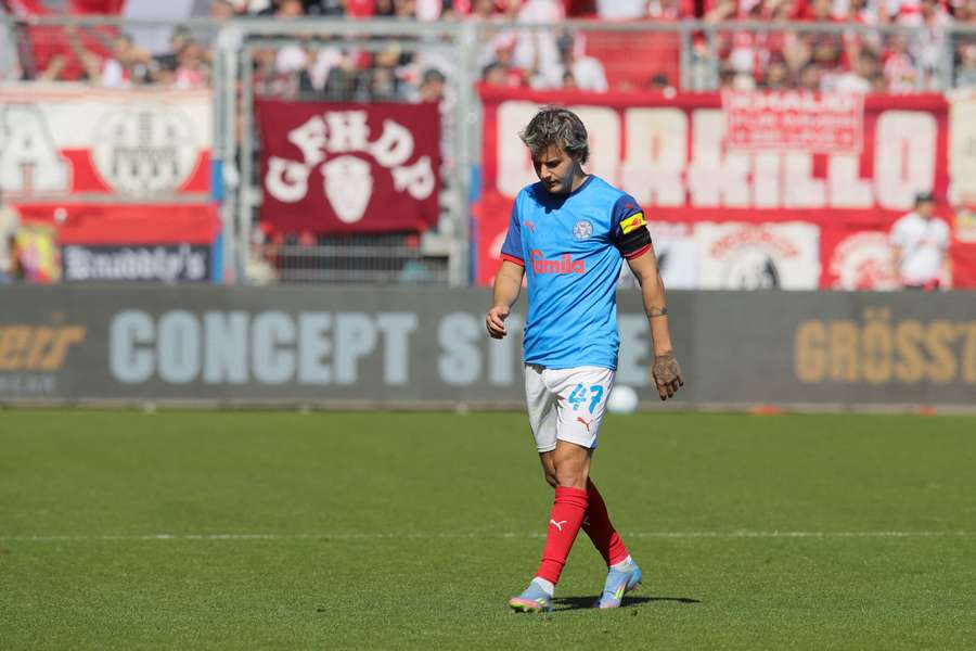 Kiel's John Tolkin walks across the pitch during the loss to Freiburg
