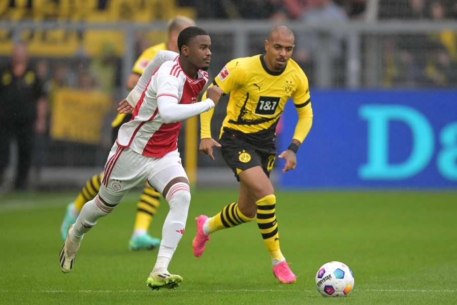 Jorrel Hato in duel met Donyell Malen van Borussia Dortmund