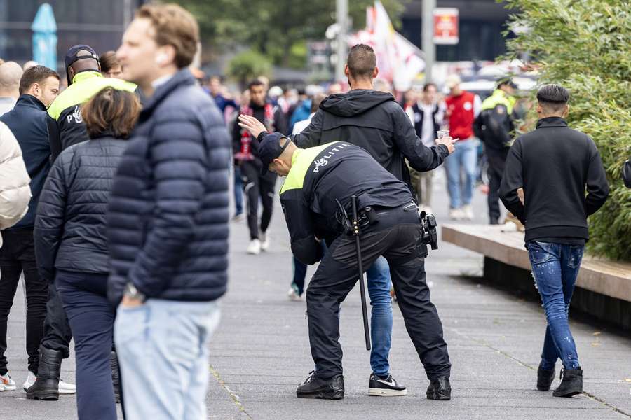 Een voetbalsupporter wordt gefouilleerd voorafgaand aan de Eredivisiewedstrijd tussen Ajax en AZ in de Johan Cruijff Arena