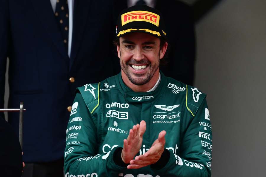 Second-placed Aston Martin driver Fernando Alonso reacts on the podium
