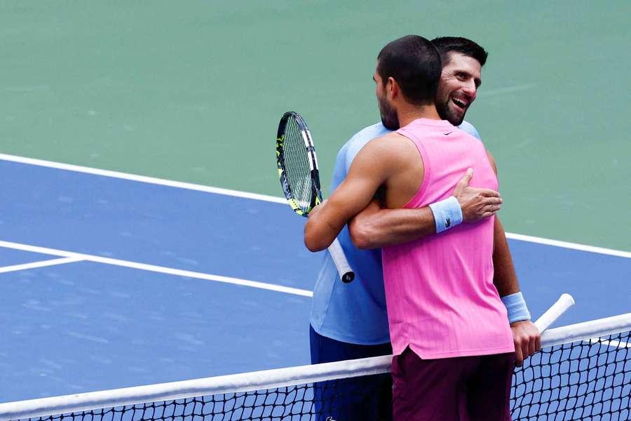 Spain's Carlos Alcaraz (right) and Serbia's Novak Djokovic hug at the net during the US Open