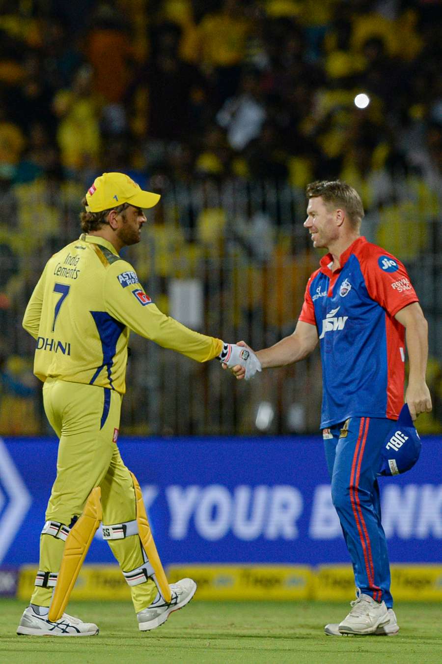 Chennai Super Kings' Mahendra Singh Dhoni (L) shakes hands with Delhi Capitals' David Warner at the end of the match
