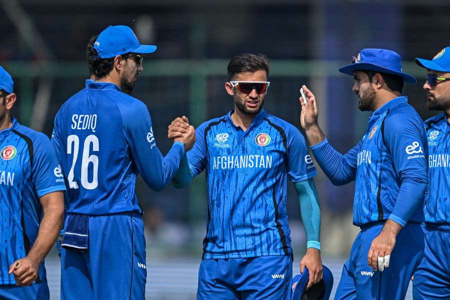 Afghanistan's Azmatullah Omarzai (C) gets congratulated by teammates