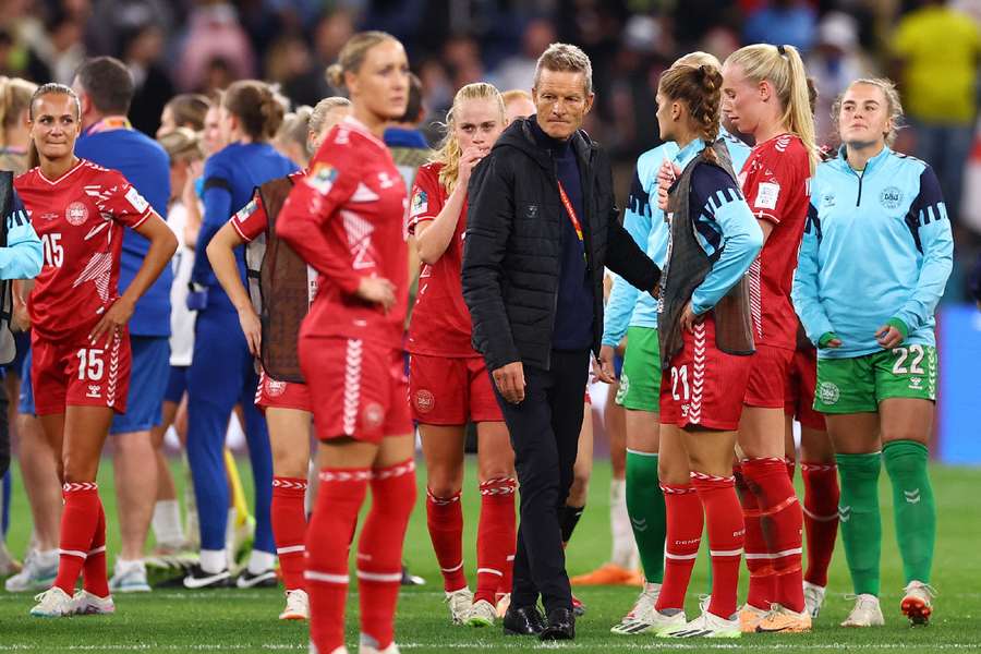 Denmark coach Lars Sondergaard and players look dejected after the match