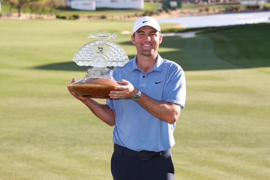 Scottie Scheffler celebrates with the trophy after winning during the final round of the Phoenix Open