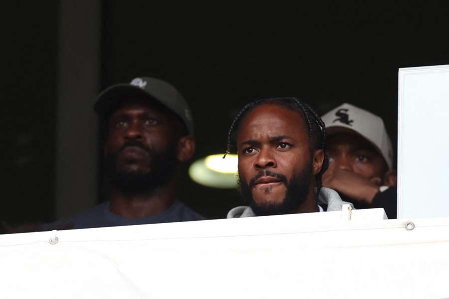 Raheem Sterling looks on from the stands during the Premier League match between Arsenal and Brighton