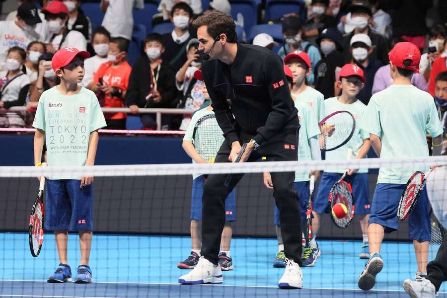 Roger Federer le arată unor copii câteva mișcări la Tokyo, în noiembrie 2022