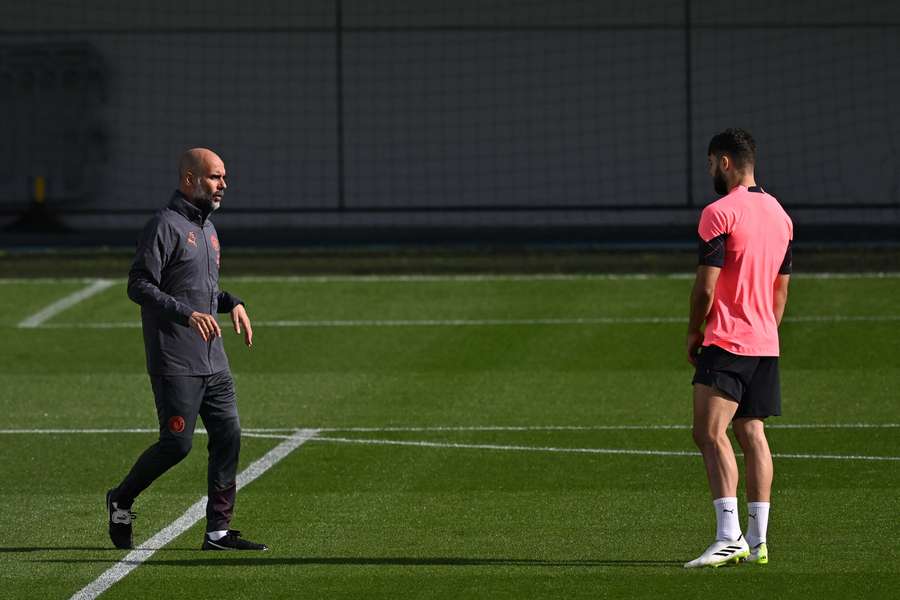 Manchester City's Spanish manager Pep Guardiola (L) speaks with Manchester City's Croatian defender #24 Josko Gvardiol (R)