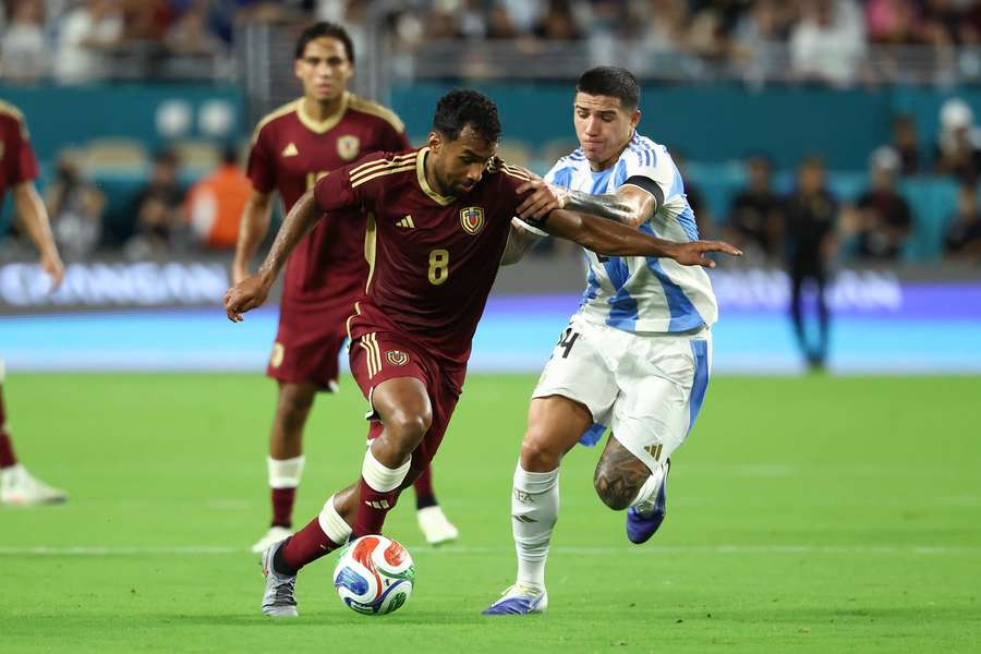 Venezuelas Casseres Jr. (l.) im Zweikampf mit dem Argentinier Enzo Fernandez (r.)
