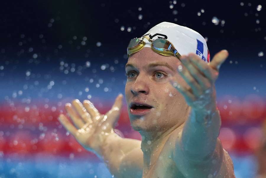 Leon Marchand celebrates in the pool