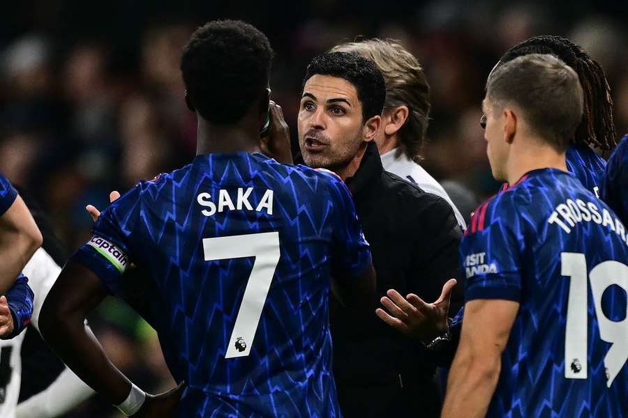 Mikel Arteta speaks with Bukayo Saka during Arsenal's win over Fulham on Saturday