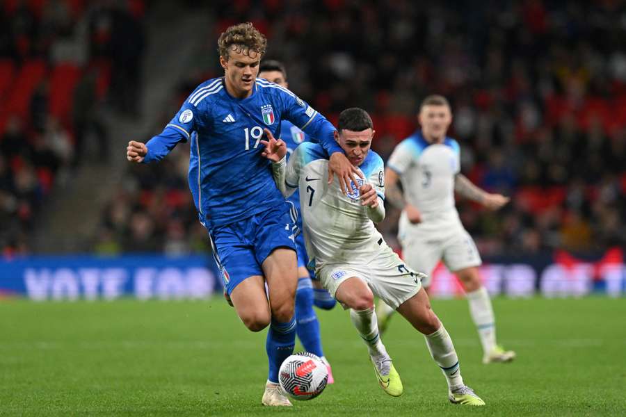 Italy's defender #19 Giorgio Scalvini (L) fights for the ball with England's midfielder #07 Phil Foden