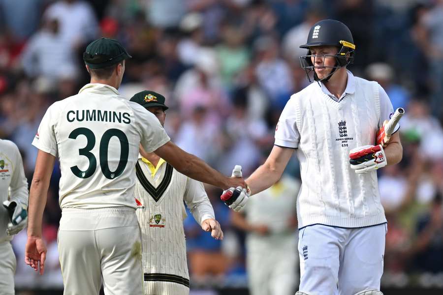 Australia's Pat Cummins (L) shakes the hand of England's Zak Crawley (R)