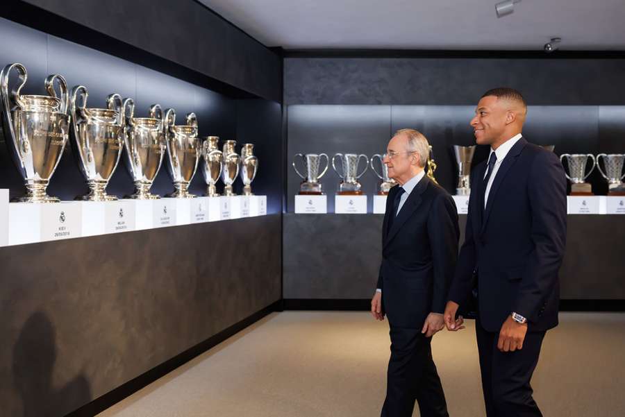 Mbappé contemplando as 15 Champions de seu novo clube