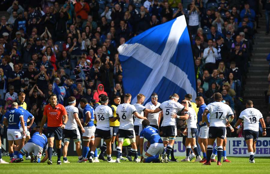 Scotland wing Darcy Graham is mobbed by teammates as he celebrates scoring the team's second try