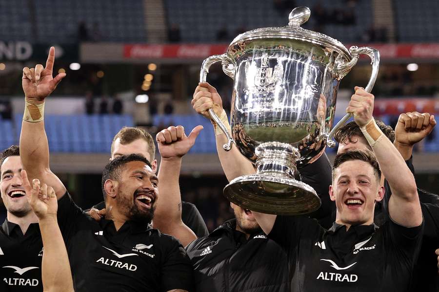 New Zealand players celebrate with the Bledisloe Cup
