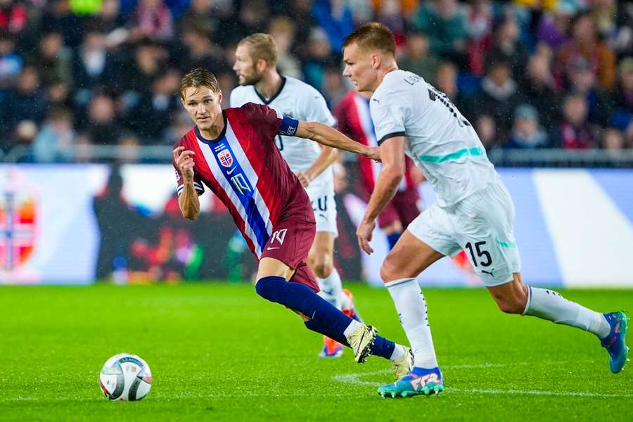 Martin Ødegaard in gevecht om te bal met Philipp Lienhart van Oostenrijk