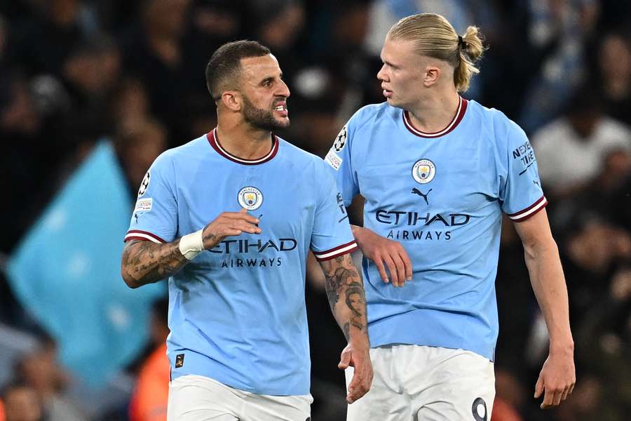 Manchester City defender Kyle Walker (L) talks with striker Erling Haaland